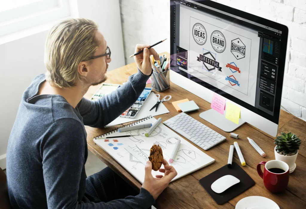 Professional graphic designer creating brand identity and logo concepts in a creative office workspace.