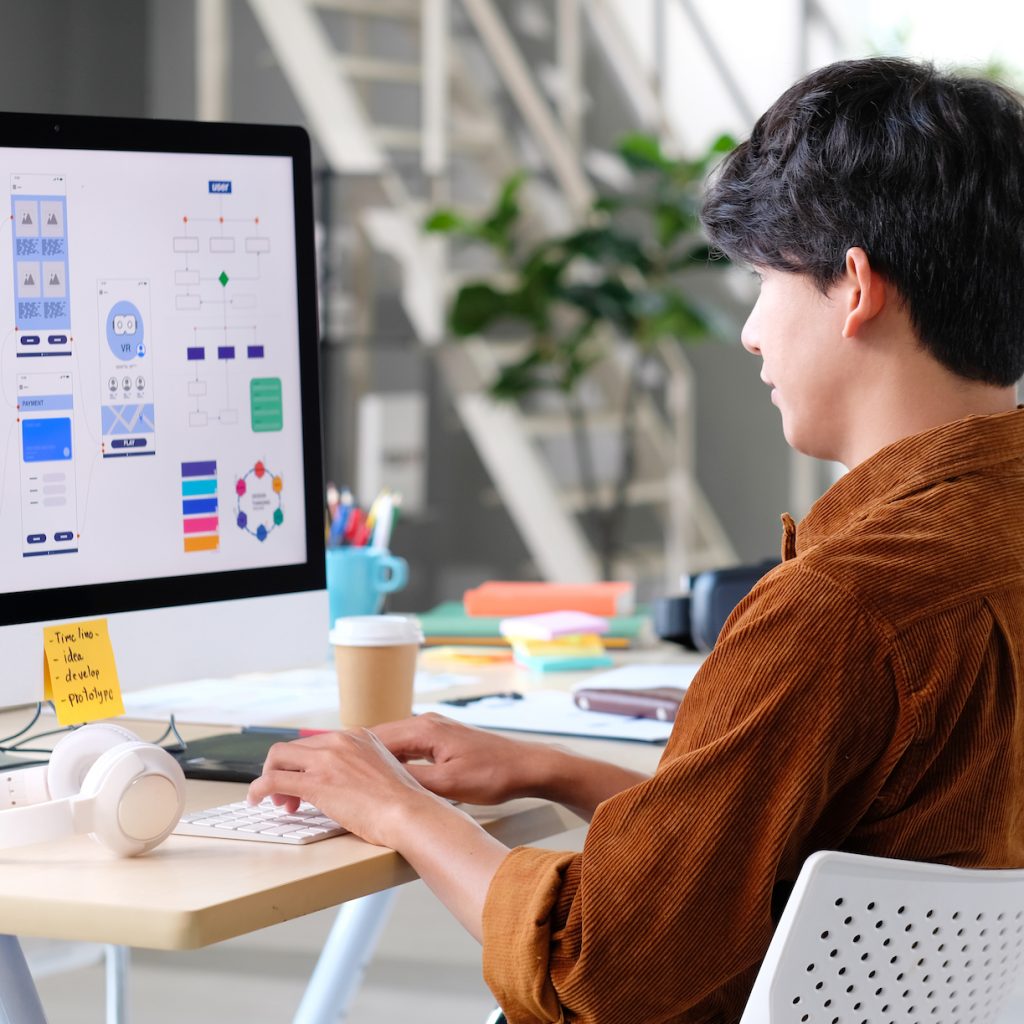 Professional web designer developing website UX/UI architecture, wireframes, and user experience flows in a modern office.